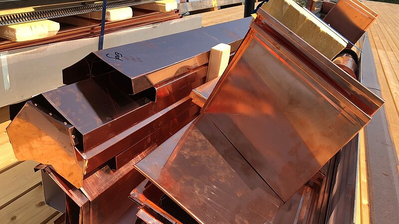 Ein durchdachter Verlegeplan gewährleistet, dass der Kranfahrer die Transportkisten optimal auf dem Metalldach positioniert – für einen schnellen und reibungslosen Montageprozess.